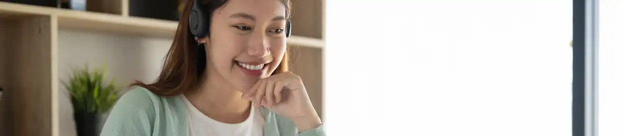 A female teacher smiles at a laptop during a lesson