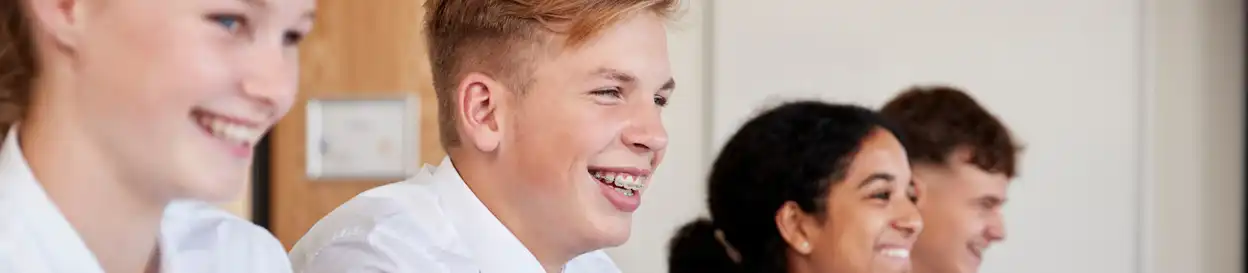 teenagers laughing and smiling in a classroom