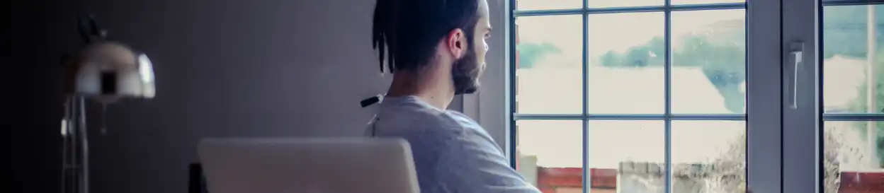 A young person looks contemplatively out the window