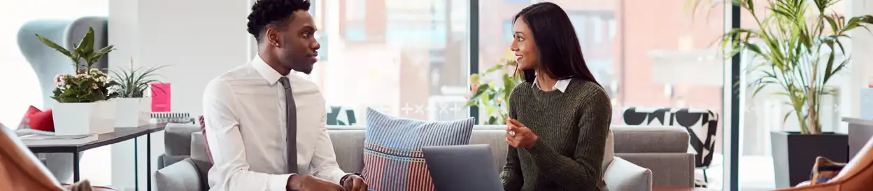 A man and a woman sitting on a couch talking 