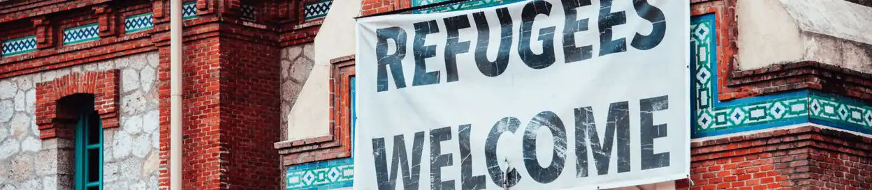 A building with a sign on it that says 'refugees welcome'